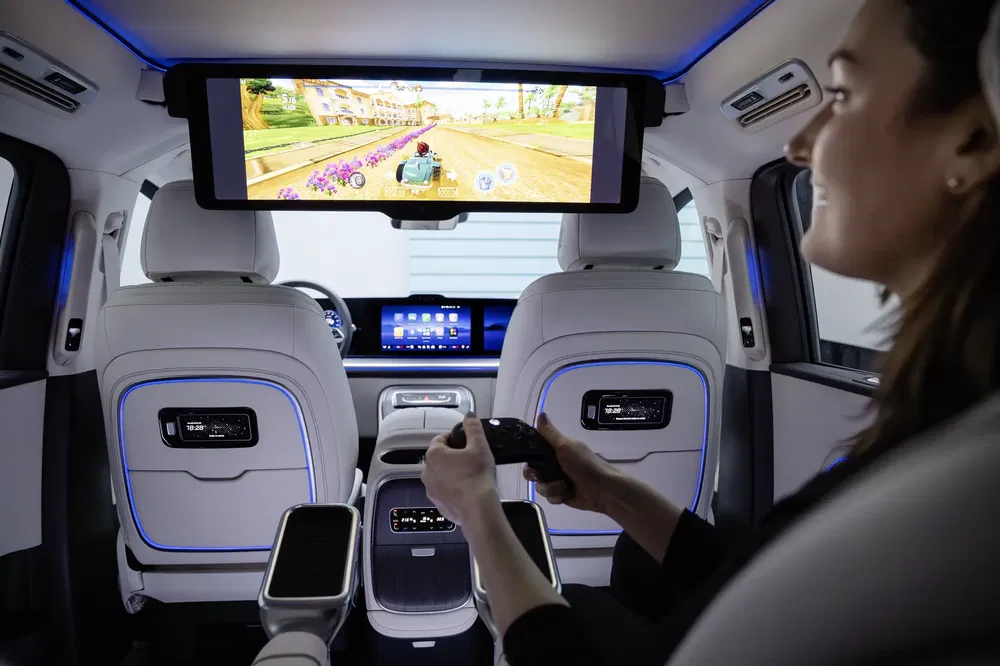 Moderne auto-interieur met videogamescherm en passagier met controller.