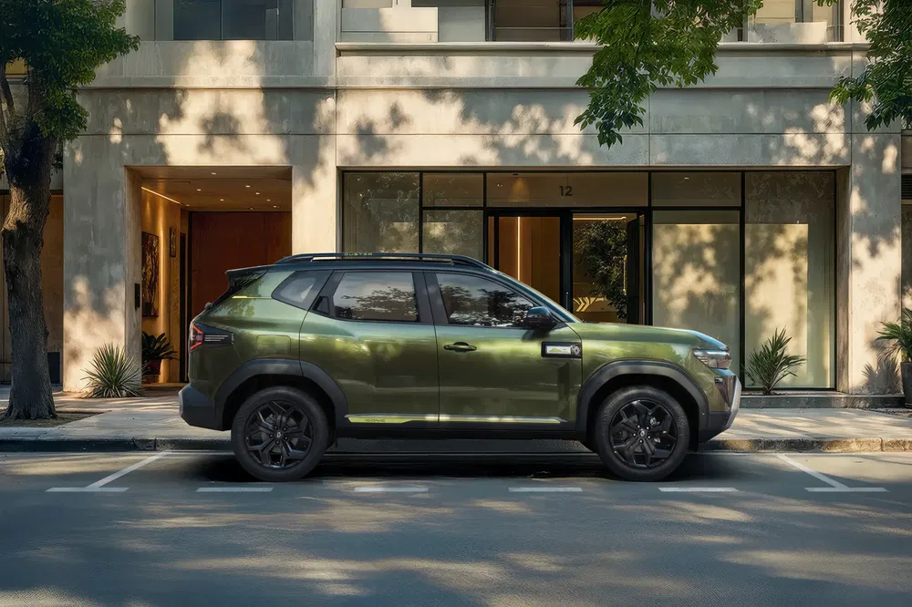 Groene Nissan Magnite geparkeerd voor een modern gebouw met stedelijke schaduwrijke bomen.