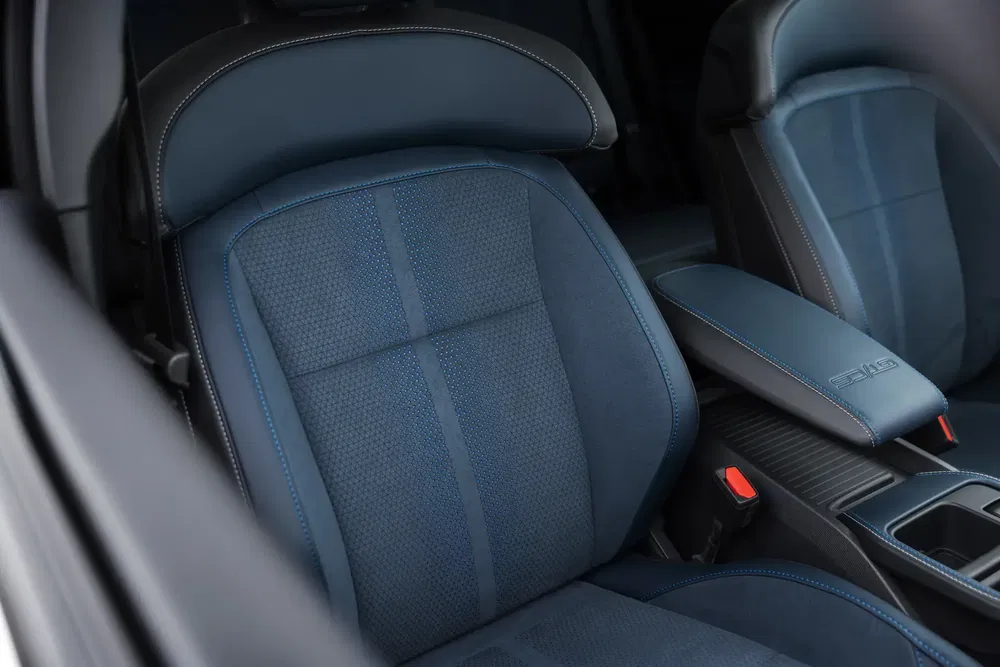 Moderne auto-interieur met blauwe stoffen stoelen en stijlvolle middenarmsteun.