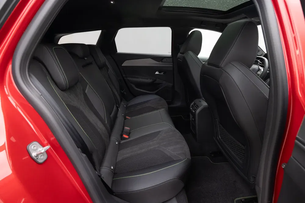 Auto interieur met zwarte lederen achterstoelen en een panoramisch zonnedak.