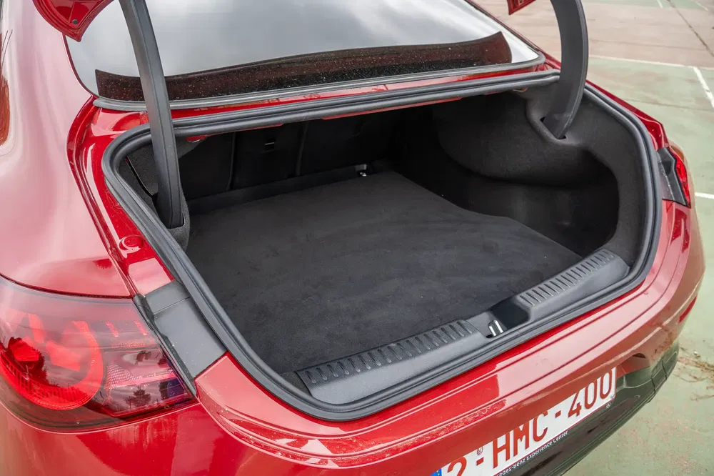 Coffre d'une voiture Kia rouge avec un grand espace de chargement ouvert.