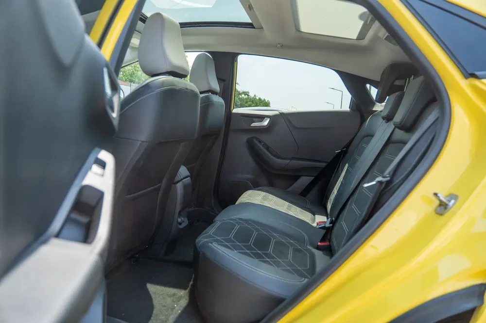 Interieur van een gele SUV met lederen stoelen en panoramisch schuifdak.