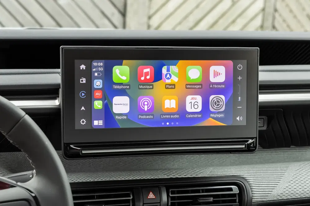 Écran tactile de voiture affichant Apple CarPlay avec diverses applications, interface moderne.