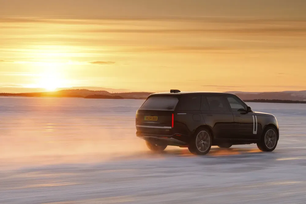 Zwarte SUV rijdt op ijs tijdens zonsondergang, toont offroad-prestaties.