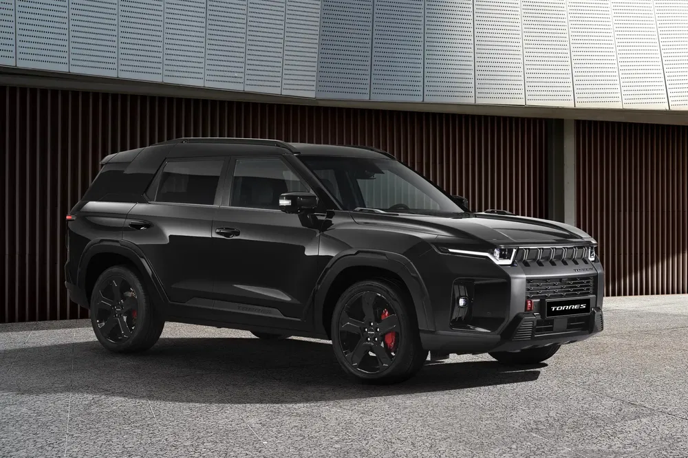 SUV SsangYong Torres noir moderne garé devant un bâtiment, design robuste et élégant.