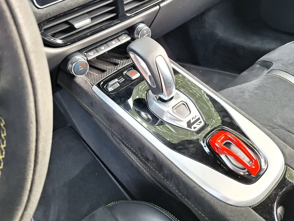 Interieur van een sportauto, gestileerde versnellingspook met koolstoffiber details.