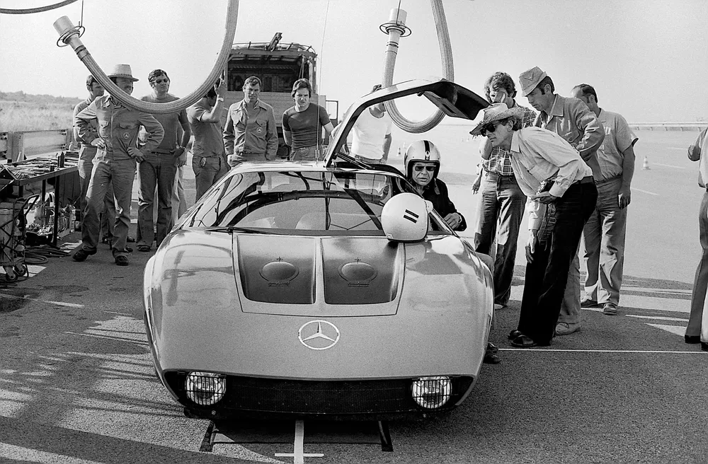 Prototype Mercedes-Benz avec portes papillon et équipage sur piste d'essai.