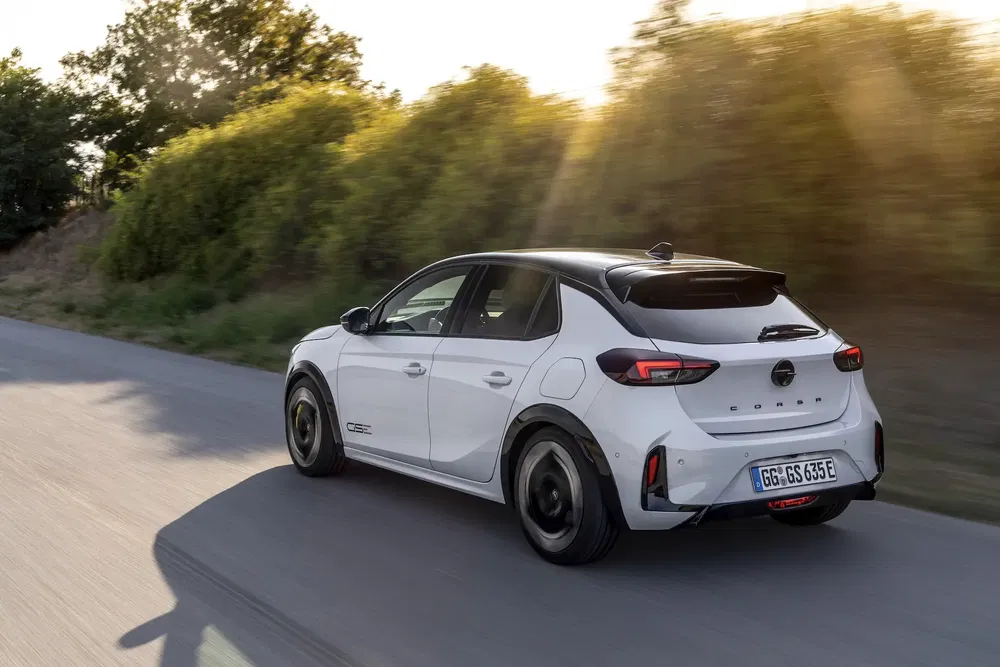 {"fr":"Opel Corsa électrique blanche sur une route, entourée de verdure et éclairée par le soleil.","nl":"Witte Opel Corsa elektrisch op weg omringd door groen, verlicht door zonnestralen."}
