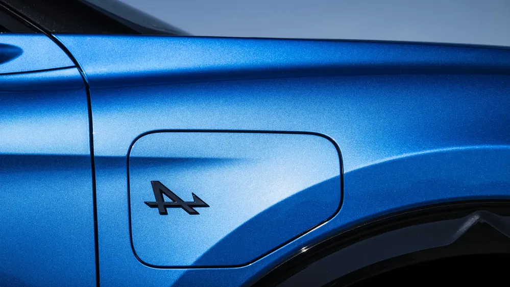 Détail de la trappe à carburant sur une Alpine A110 bleue avec logo distinctif.
