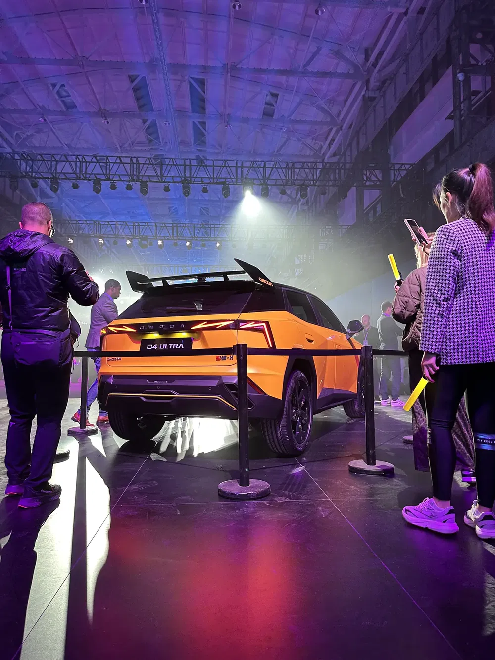 Présentation du SUV Cupra Tavascan jaune lors d'un événement nocturne avec éclairage vibrant.