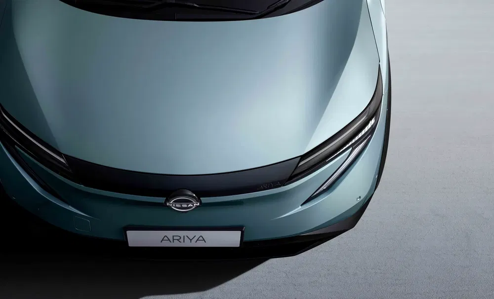 {"fr":"Vue aérienne du capot Nissan Ariya électrique bleu-gris moderne.","nl":"Bovenzicht van de moderne, elektrische Nissan Ariya met een blauw-grijze finish."}