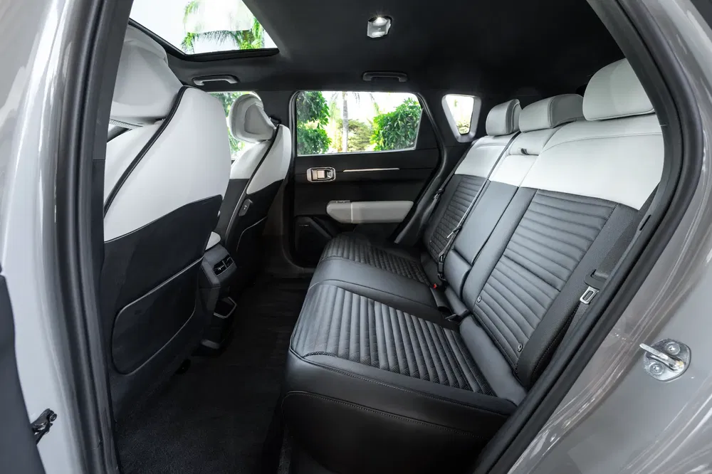 Intérieur spacieux du Kia Sportage 2023 avec sièges en cuir noir et blanc.