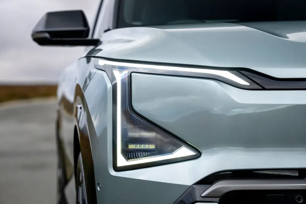 Close-up van een gestileerde LED-koplamp van een moderne Kia EV9 SUV.