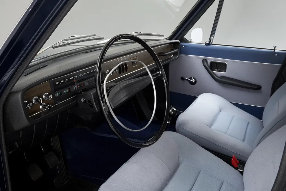 Vintage interieur van een Renault 16 met houten dashboard en klassieke stuurwiel.