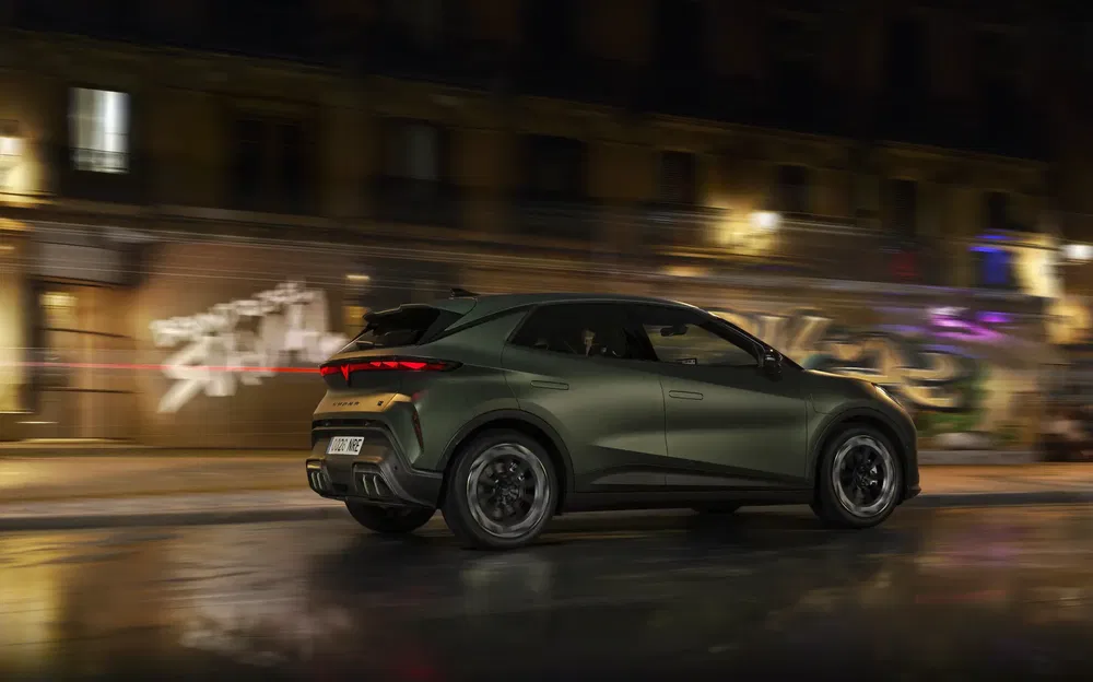 SUV moderne noir roulant en ville illuminée la nuit.