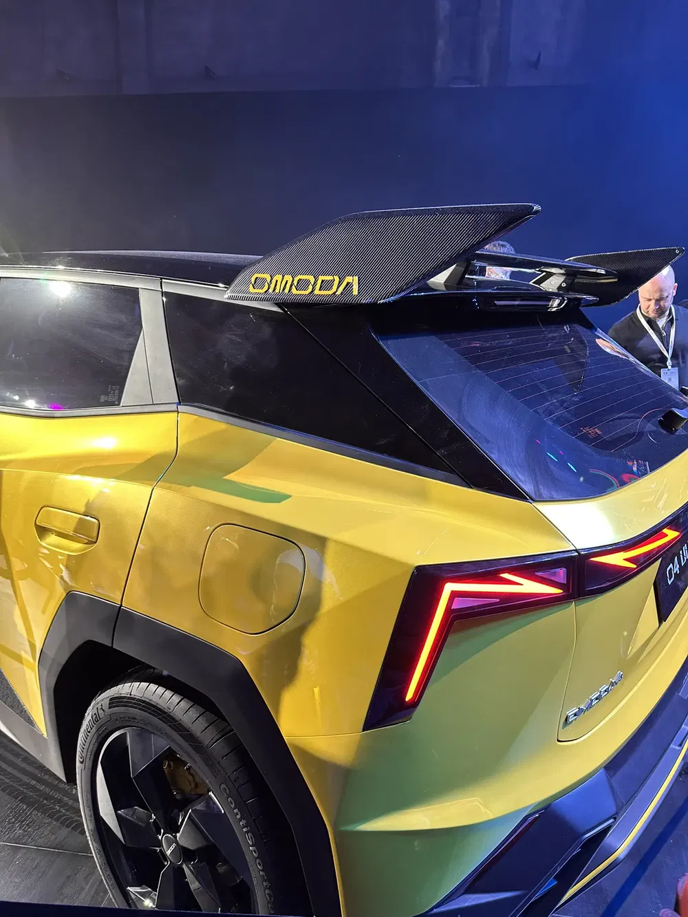 SUV OMODA jaune avec inscription sur l'aileron arrière, design moderne et sportif.