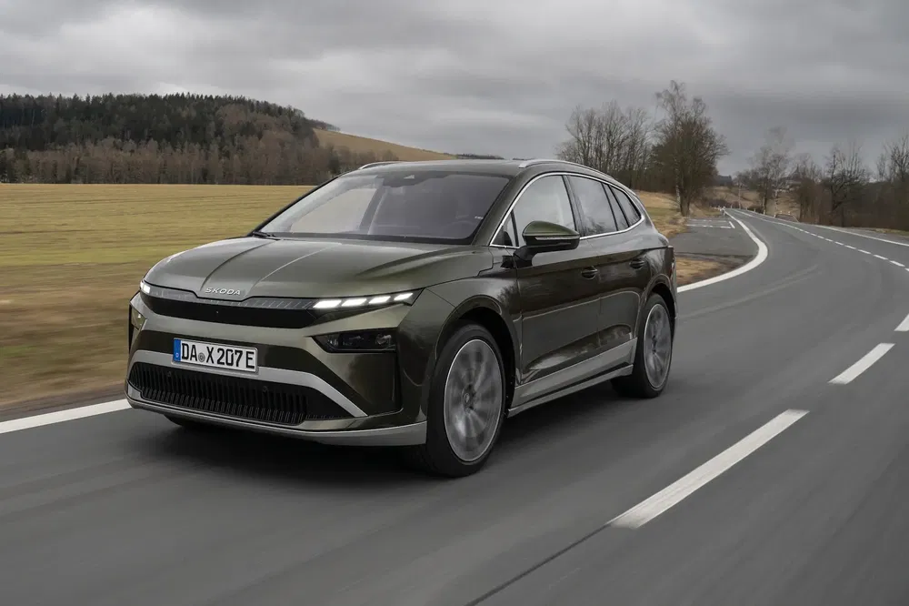 Skoda Enyaq 2024 vert sur route de campagne, ciel nuageux, vitesse dynamique.