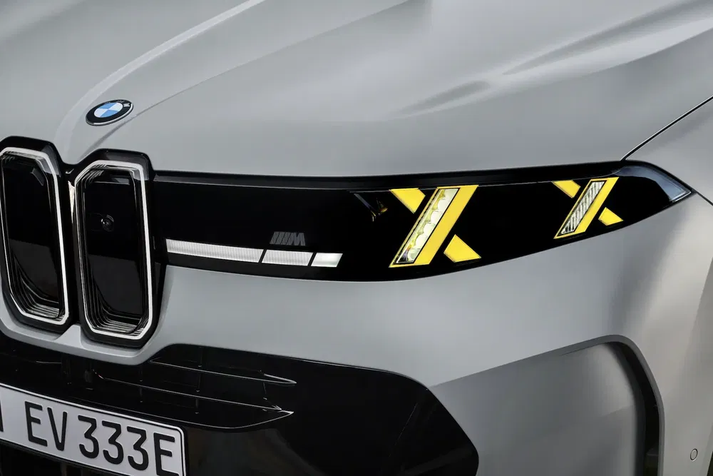 Gros plan des phares LED jaunes d'une BMW électrique avec calandre emblématique.