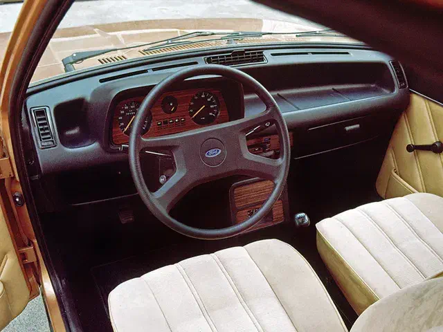 Intérieur d'une Ford rétro avec volant classique et tableau de bord en bois.