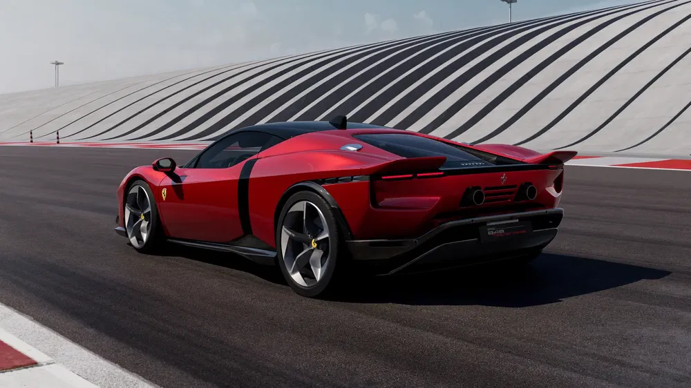 Ferrari rouge sur piste, design aérodynamique élégant, arrière de voiture visible, ciel bleu.
