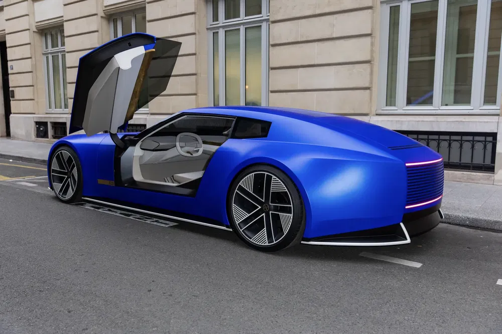 Voiture électrique futuriste bleu avec porte en élytre ouverte, design épuré sur rue pavée.