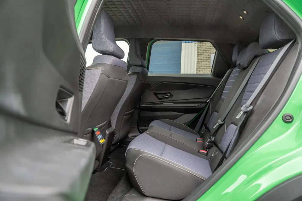 Intérieur arrière d'une voiture avec sièges en tissu gris et coutures contrastées.