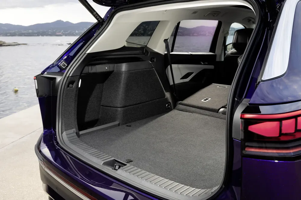 Ruime kofferbak van Volkswagen ID.4 SUV met neerklapbare achterstoelen, uitzicht op het meer.