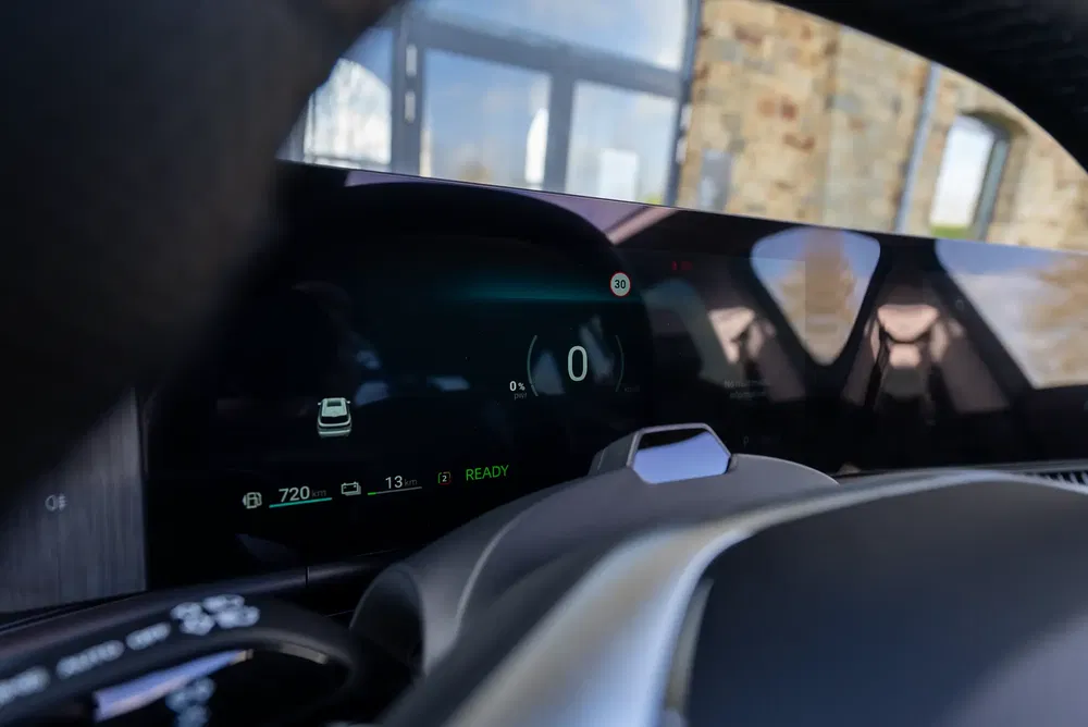 Digitaal dashboard van een elektrische auto met snelheid en resterende actieradius weergegeven.