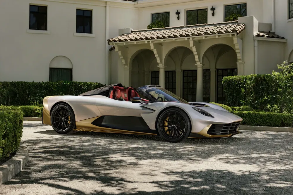 Voiture Ferrari Roma beige et noire stationnée devant une grande maison.