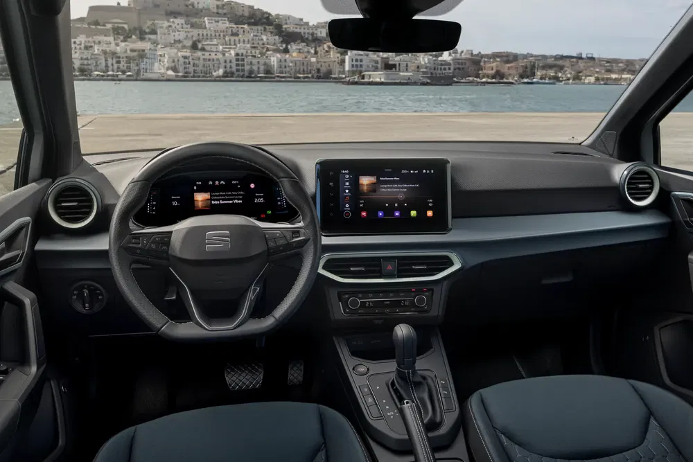 Modern interieur van Seat Ibiza met touchscreen bij een kustlijn.