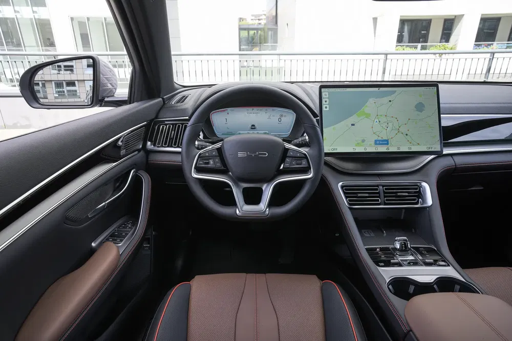 Intérieur moderne d'une voiture BYD avec tableau de bord numérique et écran tactile intégré.