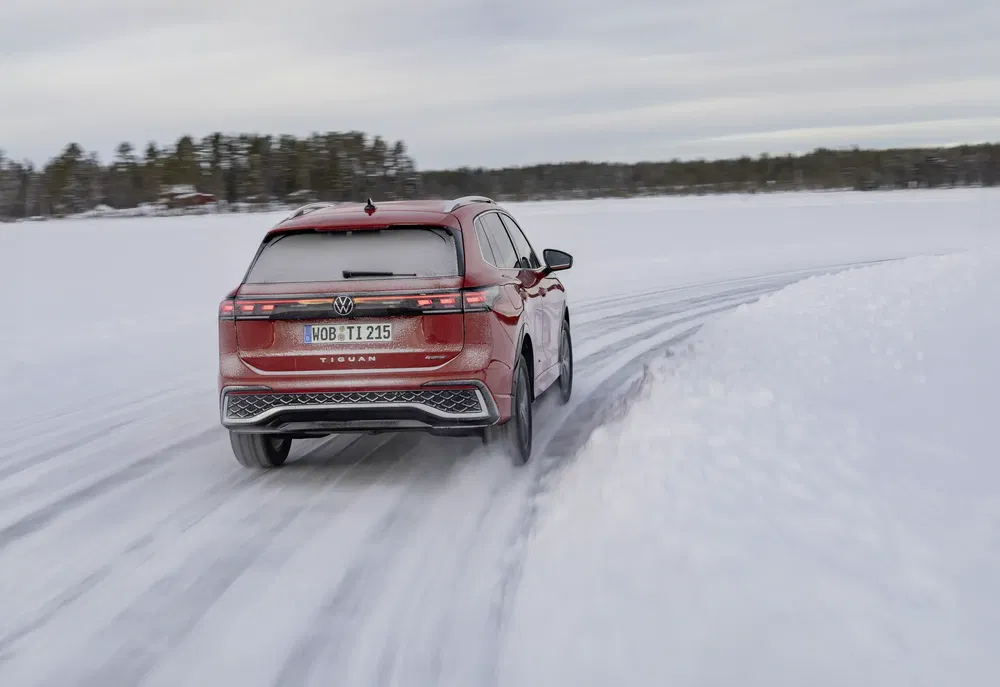 Rode Volkswagen Tiguan SUV op besneeuwd parcours, toont winterse wendbaarheid.