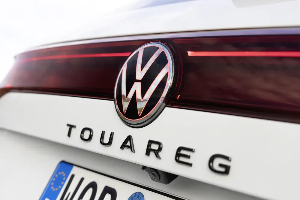 {"fr":"Détail du logo Volkswagen sur l'arrière d'un Touareg blanc moderne.","nl":"Detail van Volkswagen logo op de achterkant van een moderne witte Touareg."}