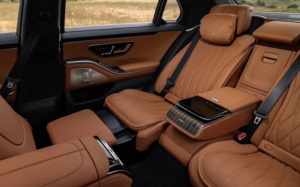 Intérieur luxueux d'une voiture avec sièges en cuir brun et tablette centrale sophistiquée.