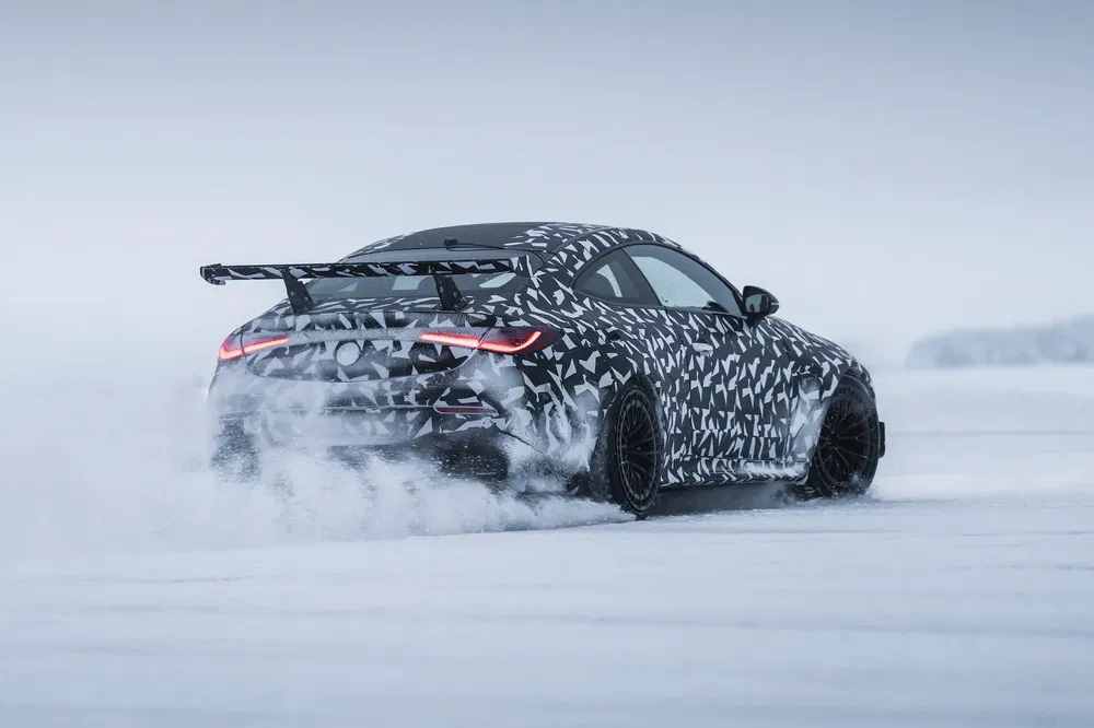 Camouflage sportauto glijdt door sneeuw, opvallende achtervleugels benadrukken kracht en snelheid.