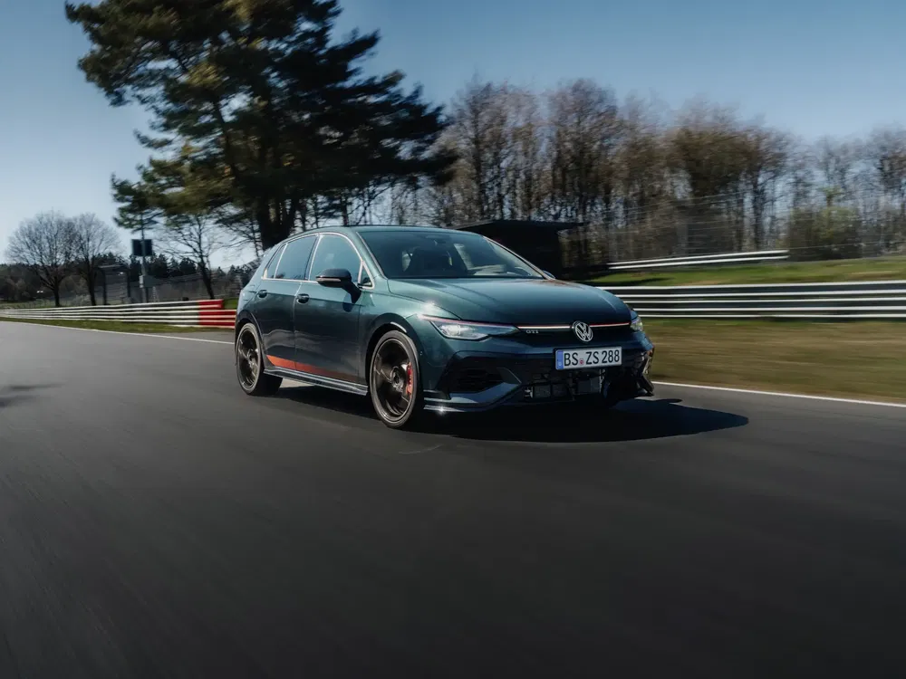 {"fr":"Volkswagen Golf GTI en pleine vitesse sur circuit automobile entouré de paysages boisés.","nl":"Volkswagen Golf GTI op hoge snelheid op een racecircuit omgeven door bosrijke landschappen."}
