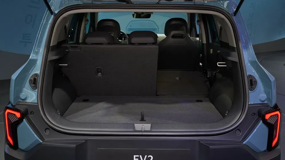 Coffre spacieux d'un Hyundai Casper EV, sièges arrière partiellement rabattus, éclairage moderne.