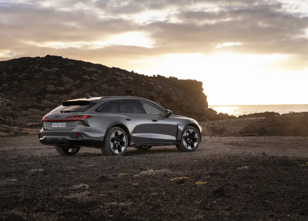 Grijze Audi RS6 allroad bij zonsondergang op rotsachtig terrein.
