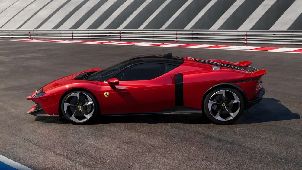 Ferrari JC20 rouge sur circuit, design aérodynamique, roues en alliage, ciel bleu.