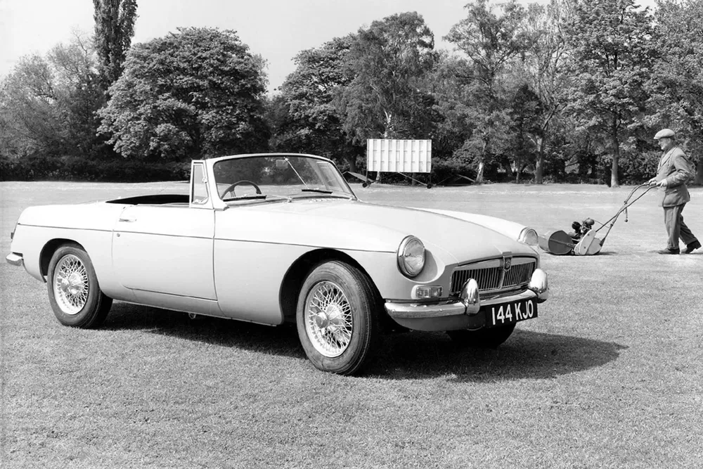 MG MGB cabriolet classique sur pelouse avec golfeur en arrière-plan.