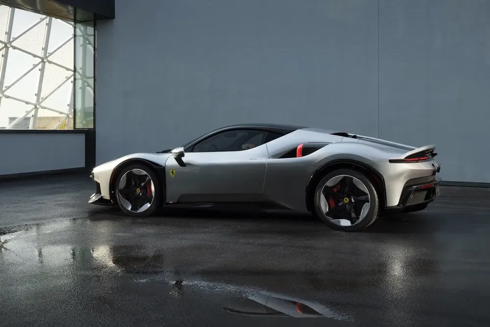 Moderne grijze Ferrari geparkeerd in een stijlvolle garage met spiegelende vloer.