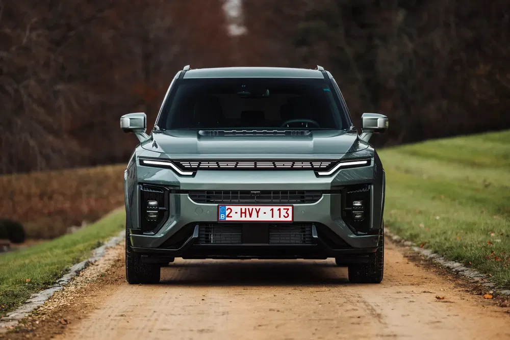 Voorzijde van een SsangYong Torres SUV op een landweg in de herfst.