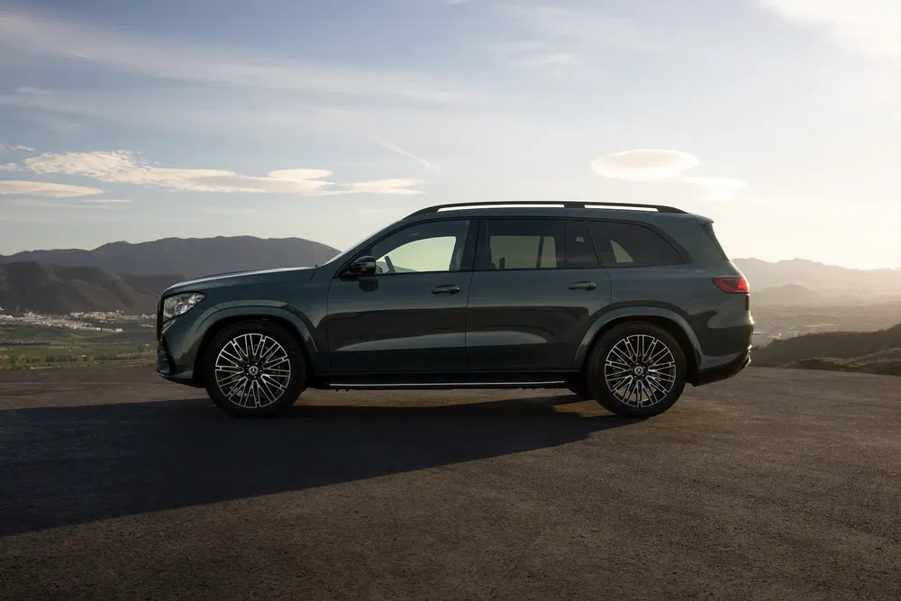 SUV Mercedes-Benz GLS profilé au coucher du soleil sur fond de montagne pittoresque.