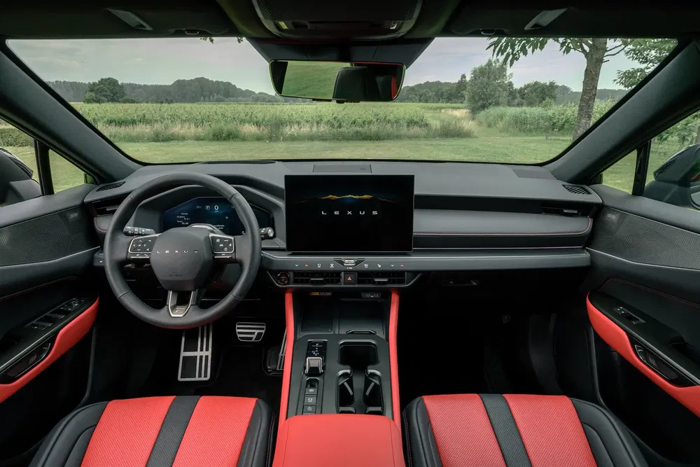 Intérieur de voiture Lexus, sièges rouges et écran central dans un cadre champêtre.