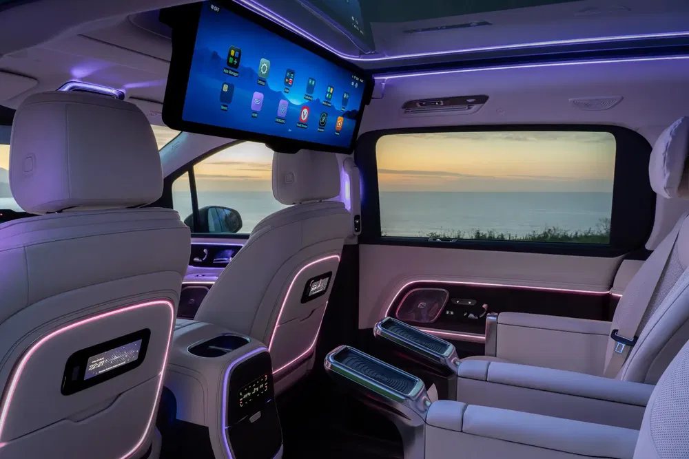Intérieur luxueux d'un monospace avec éclairage LED violet et écran inclinable.