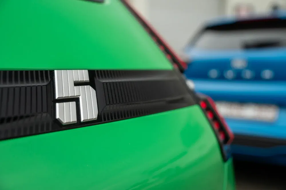 Gros plan sur l'arrière d'une Fiat 600 électrique verte, floue à côté d'une bleue.
