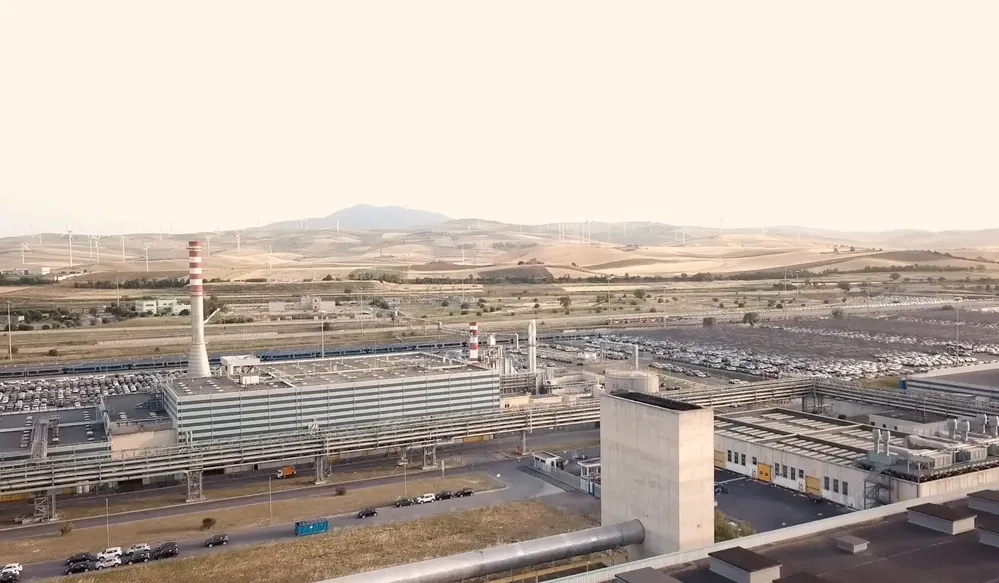 Vue aérienne d'une usine industrielle avec une vaste aire de stationnement pour les voitures.
