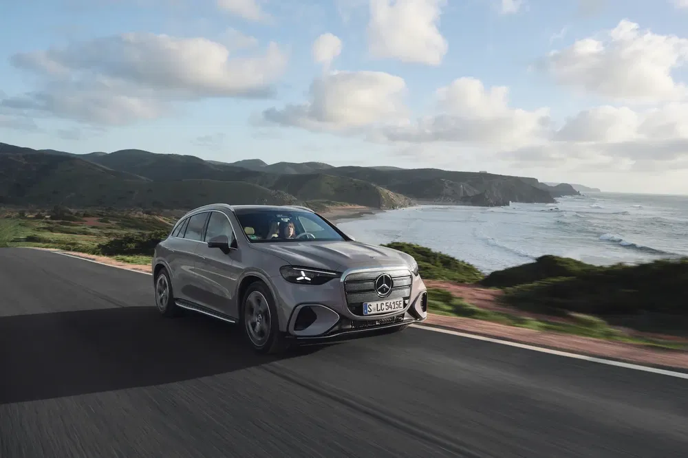 Mercedes-Benz EQA grise roulant sur une route côtière panoramique.