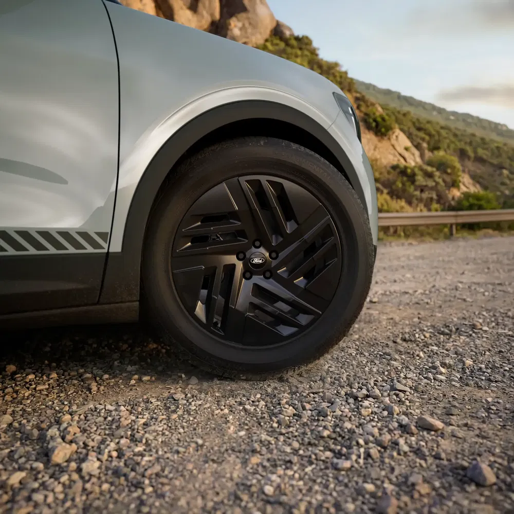 Détail de roue Ford sur chemin de gravier, soulignant son design moderne en plein air.