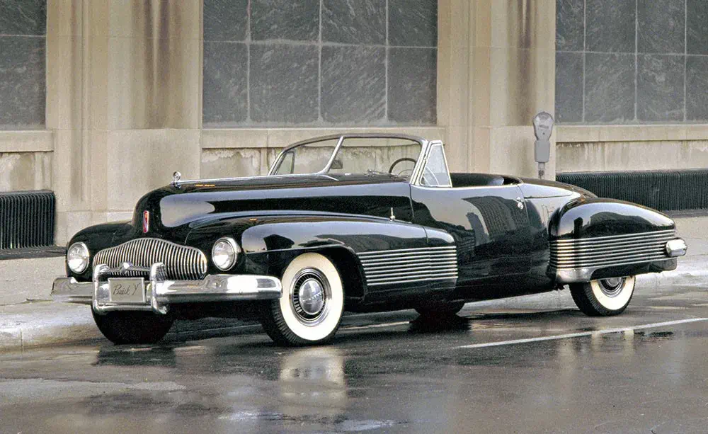 Buick Y-Job noir classique, cabriolet élégant, stationné devant un bâtiment ancien.